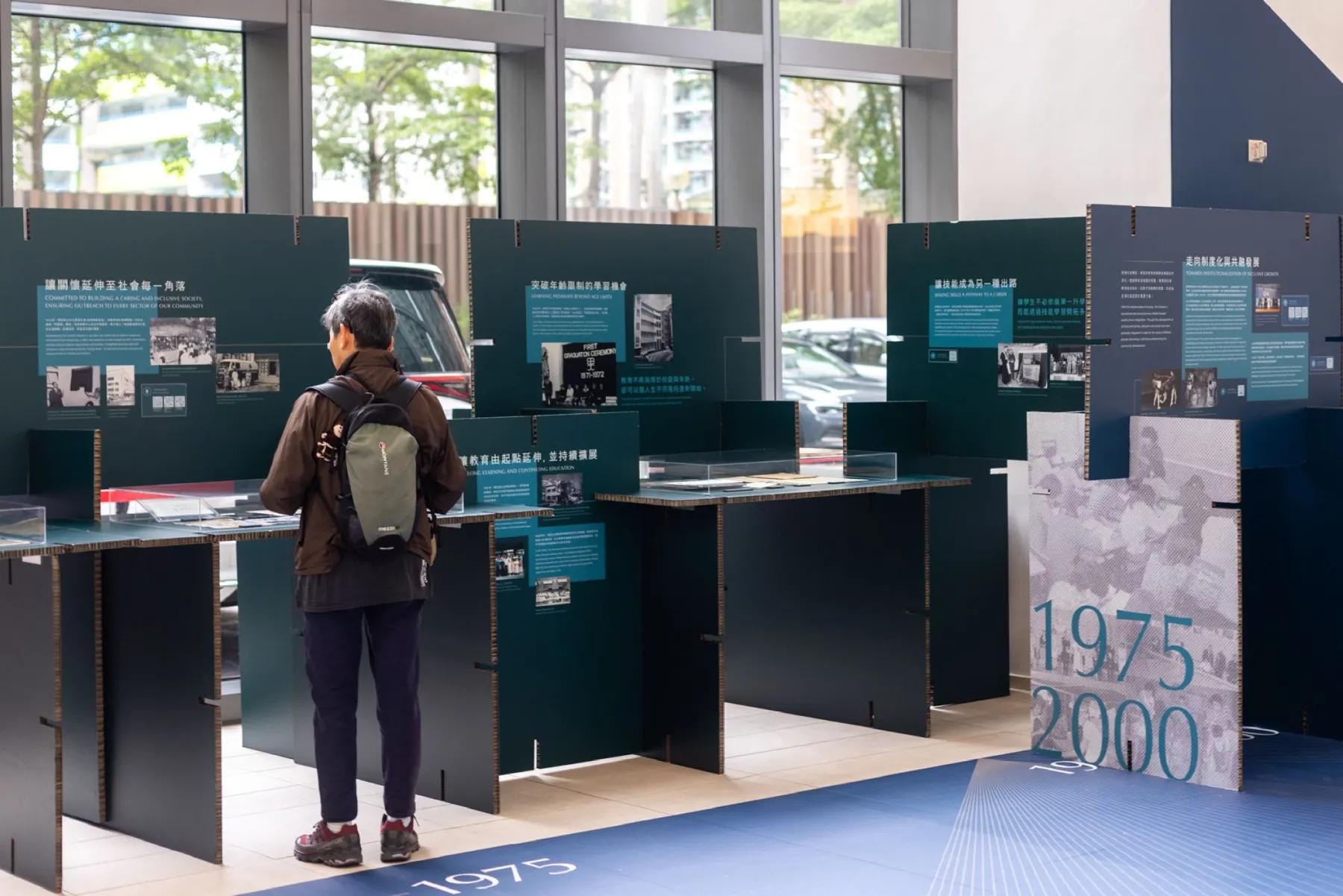 A visitor reading a panel in the 1975 to 2000 section of the exhibition